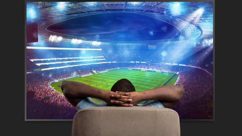 man watching large TV