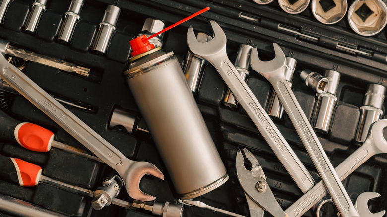 A full toolbox with an unbranded can of lubricant on top