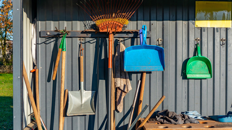 A shed with a collection of wooden garden tools