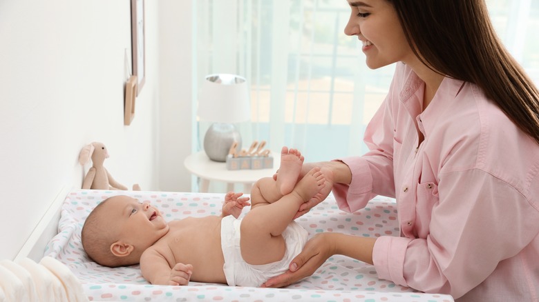 mother changing her baby's diaper 