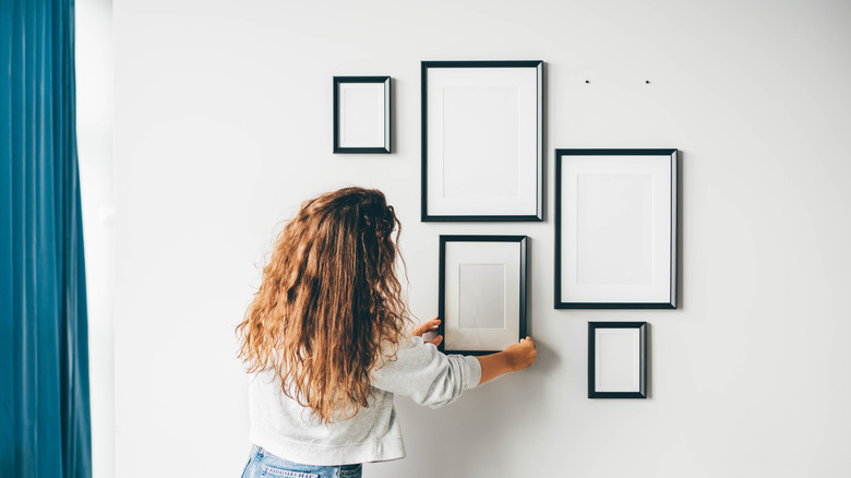 Person hanging frames