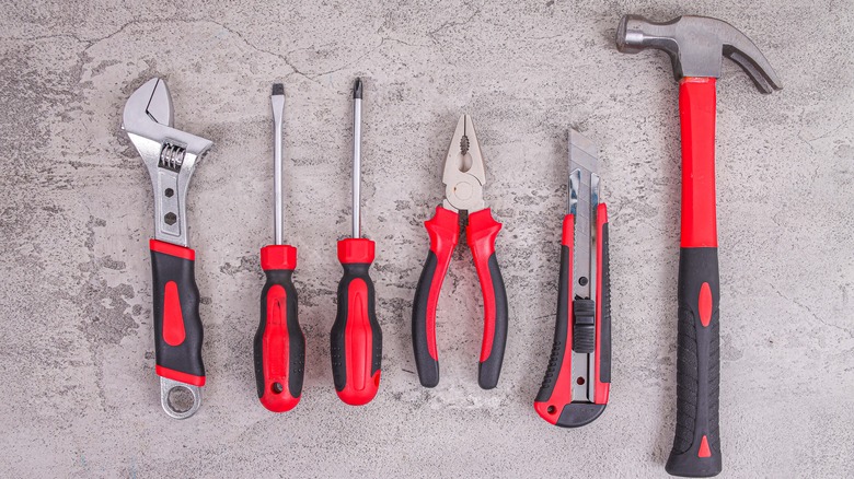 Black and red toolkit including hammer, pliers, and screwdrivers