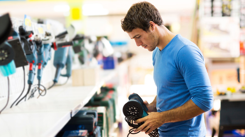 Man shopping for sanding machines at a hardware store