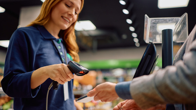 Female store associate scanning a coupon on a phone