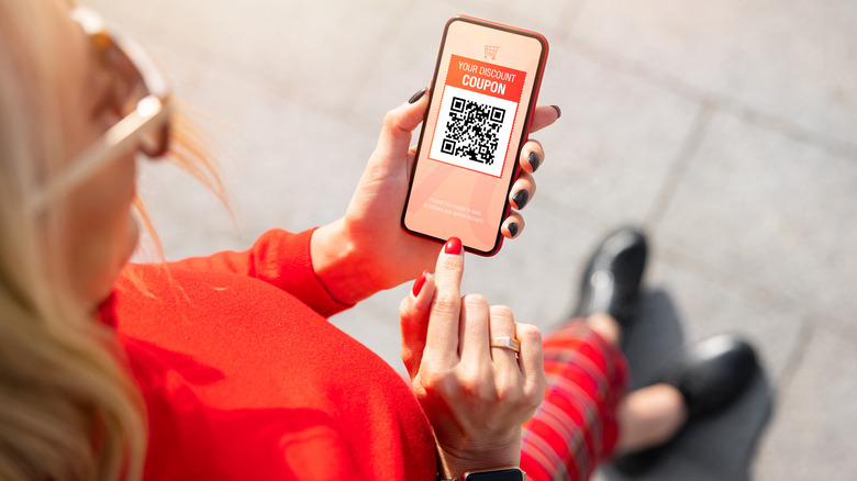 A woman holding a virtual coupon