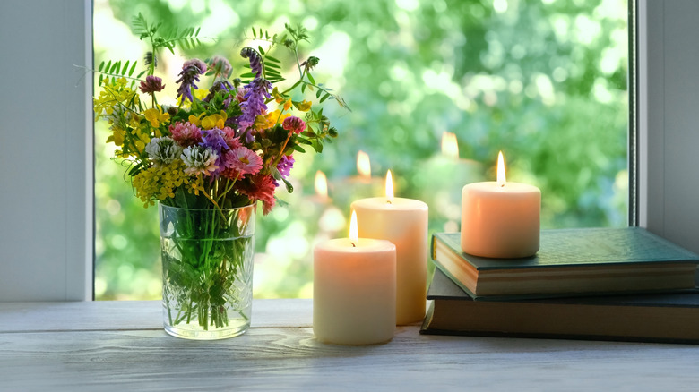 Candles and flowers on windowsill