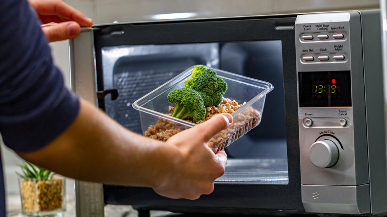 Person reheating food in microwave