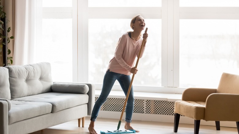 Woman singing into a Swiffer 