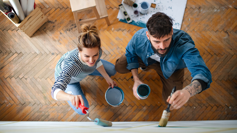 Two people painting a wall