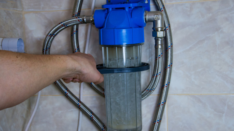 A person setting up a water softener