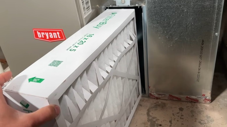 person replacing a thick air filter in HVAC system