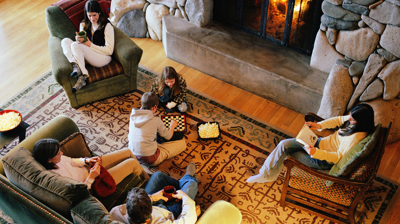 family of six sitting together in front of a fireplace in a living room