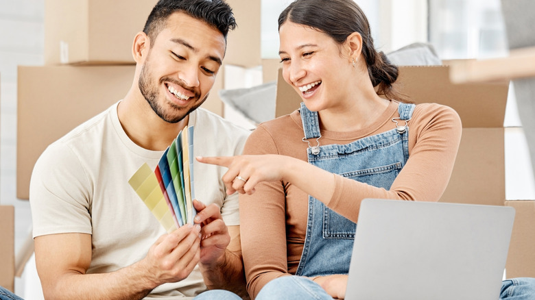 Couple choosing colors on sample palette after moving into home