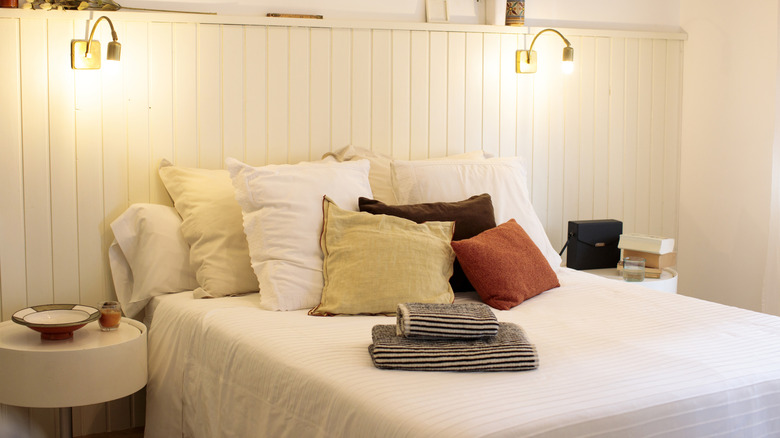 boho chic bedroom with white bedding and lots of throw pillows