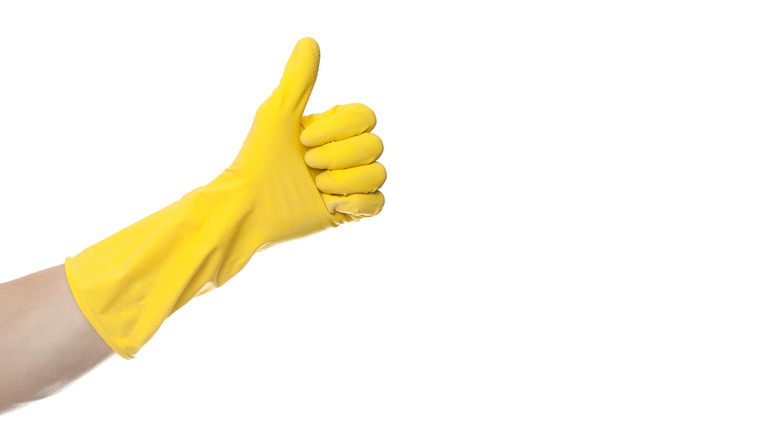 Thumbs up hand wearing gloves