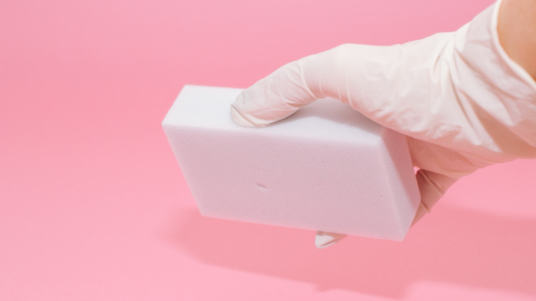 Gloved hand using magic eraser