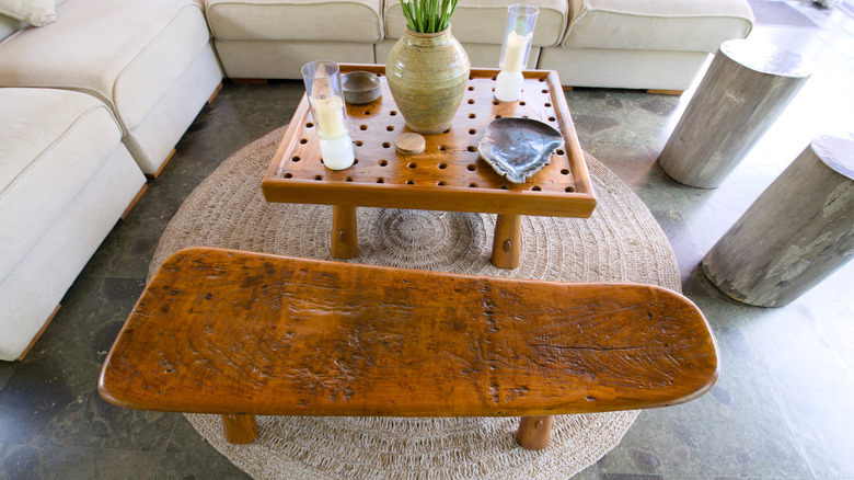 a rustic wooden bench next to a coffee table in a living room