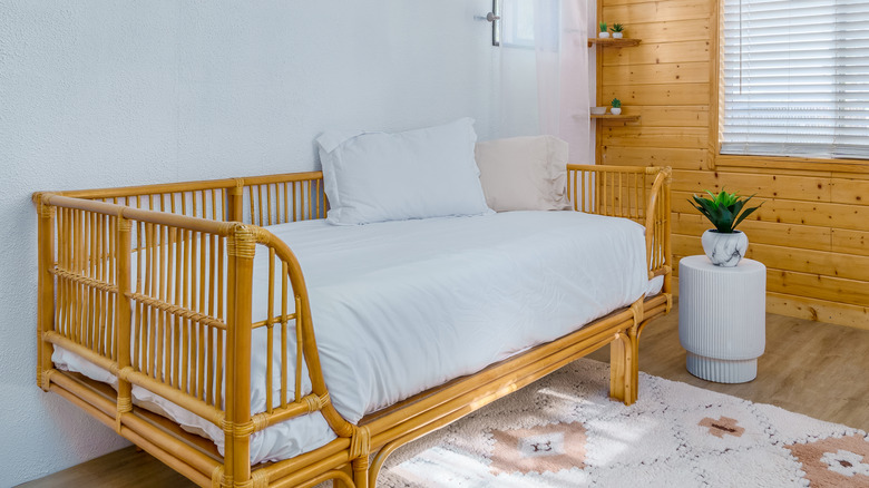 a rattan boho style daybed in a rustic room