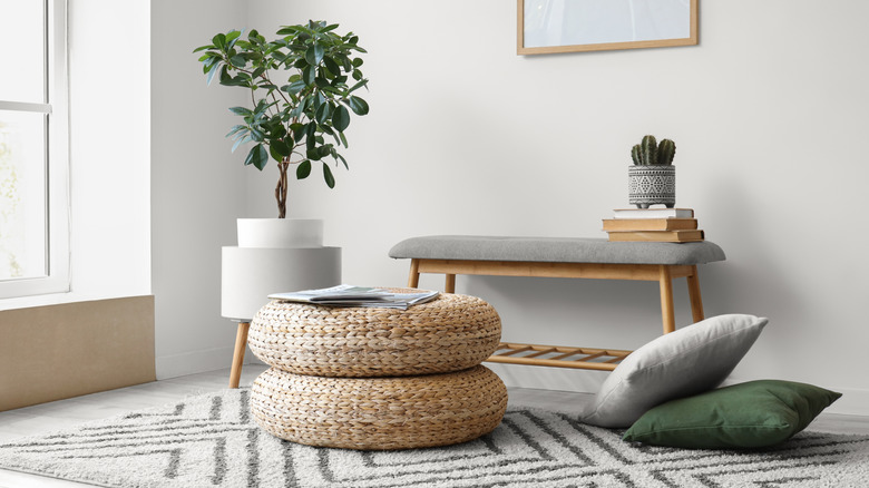 modern living room with a bench and wicker ottoman
