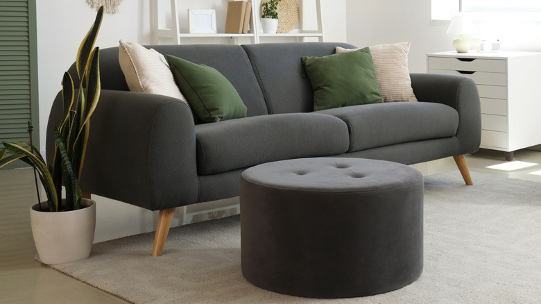 gray round ottoman next to small sofa in living room