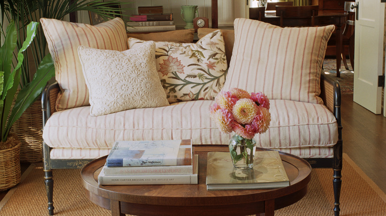 a settee and cluttered coffee table decorated in a rustic style