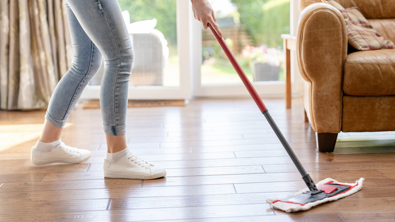 Person using swiffer on wooden floor