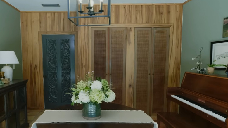 Wood paneled wall with woven cane closet doors