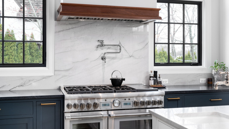 A luxury kitchen with a large range oven and pot-filler faucet
