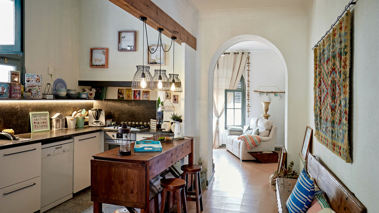 Modern rustic kitchen with wooden beam, high table, and barstool chairs