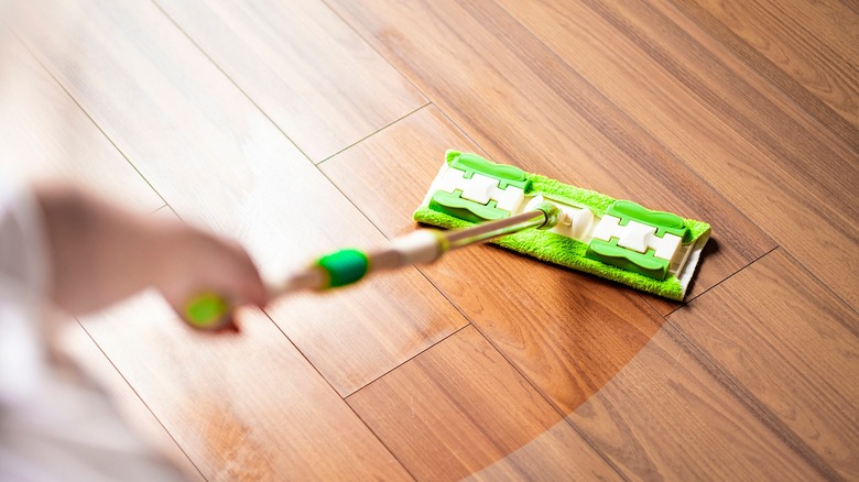 person mopping hardwood floor