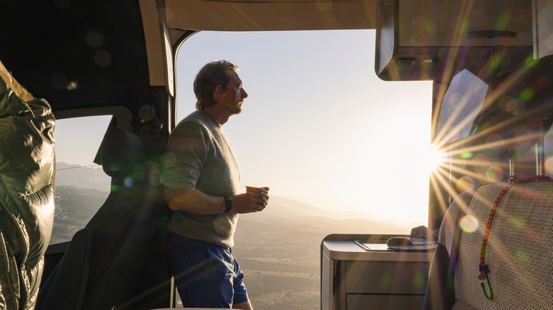 A man standing in an RV looking outside