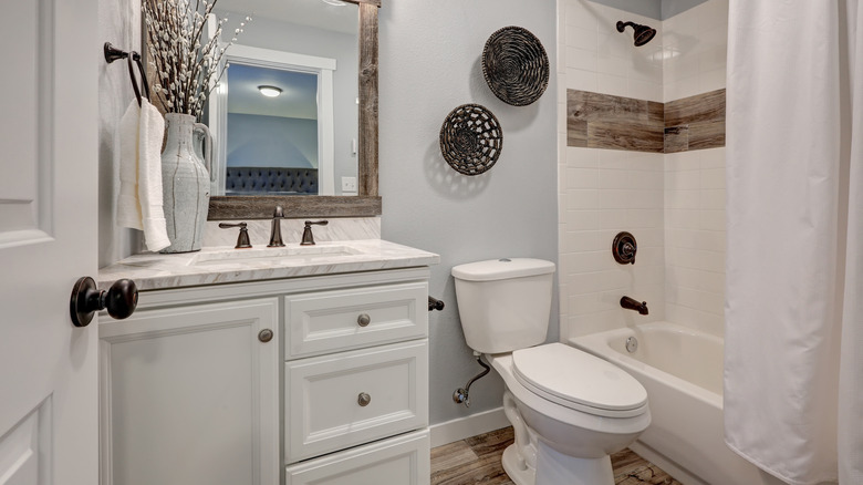 A bathroom with reclaimed wood floor and accents.