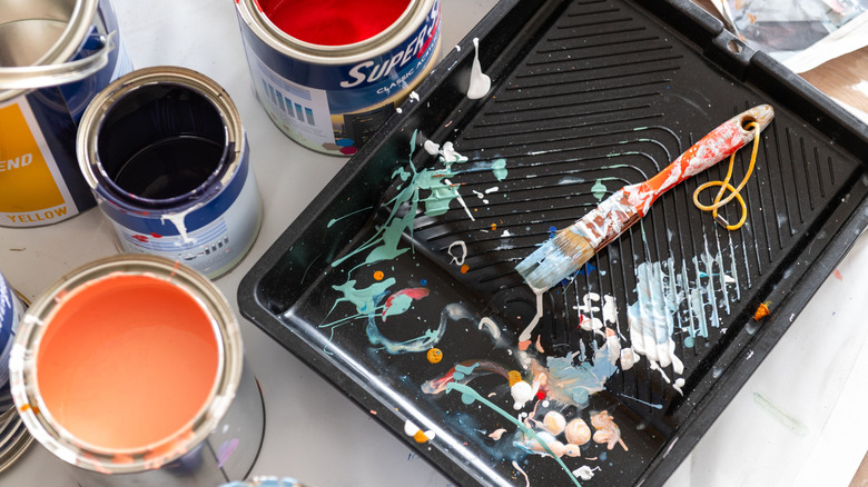 Paint cans, a tray, and other paint supplies.