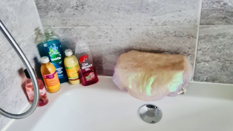 Shower cap covers tub taps to protect them from shower water that would produce lime scale.