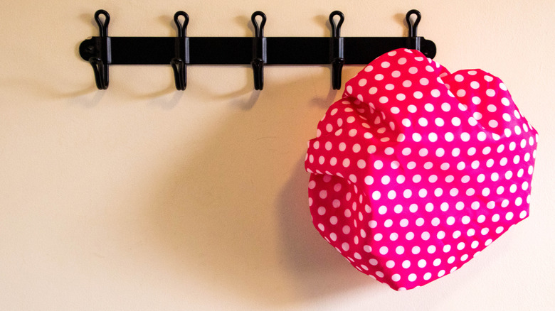A polka dot shower cap hanging in the bathroom