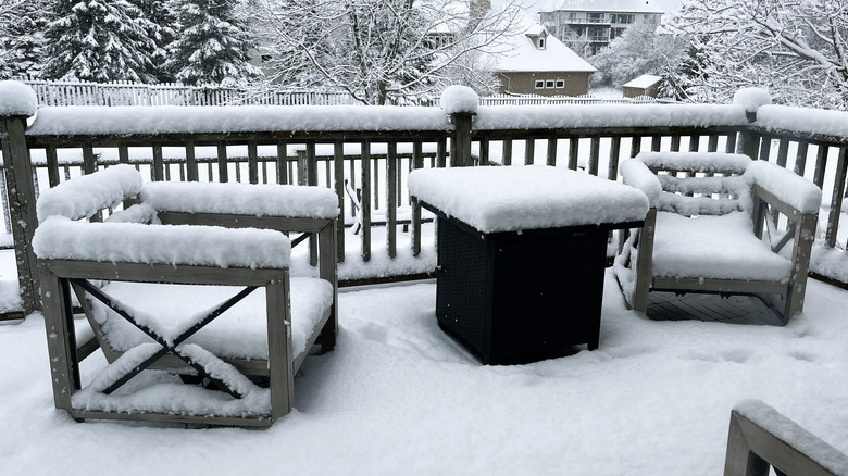 Snow building up on deck furniture and railing