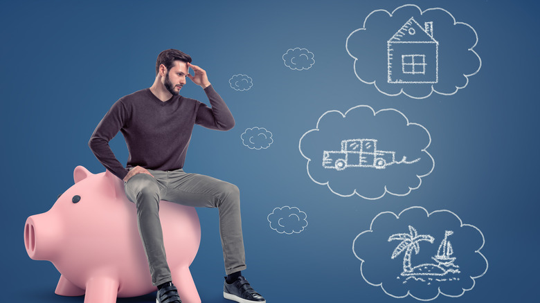 man pondering on piggy bank