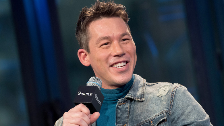 David Bromstad smiling and holding a microphone.
