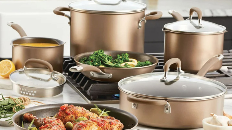 Circulon Premier Professional Cookware Set on a stove and counter with food and ingredients