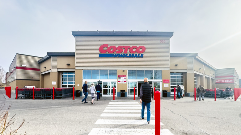 People walking into a Costco warehouse storefront