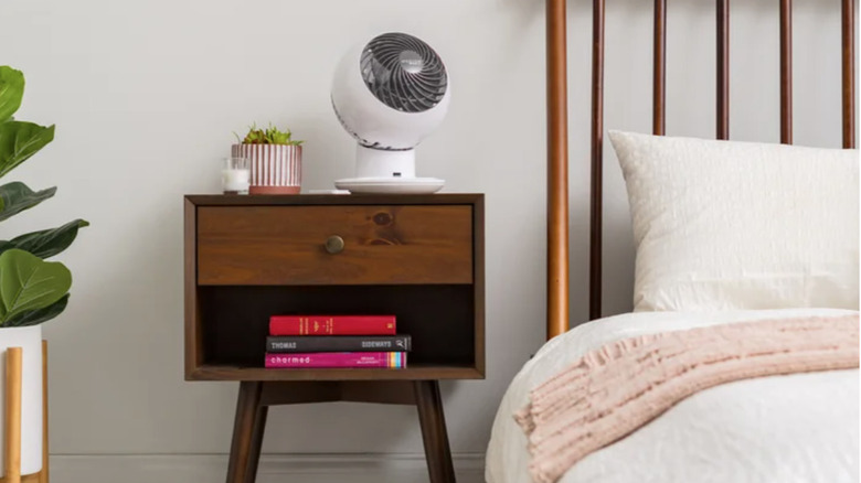 The Woozoo 5-Speed Globe Fan on a nightstand in a bedroom