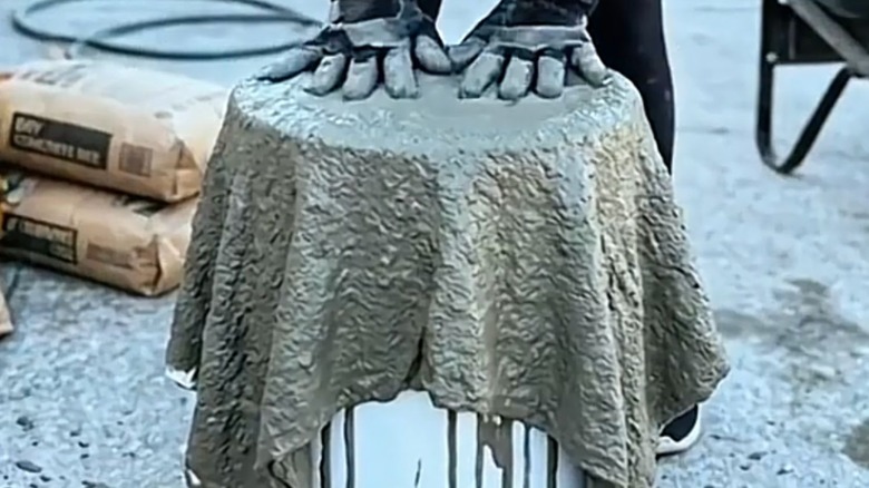 Placing cement soaked fabric on an upturned bucket