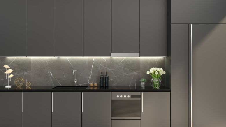 A gray kitchen with mostly hidden cabinets and appliances