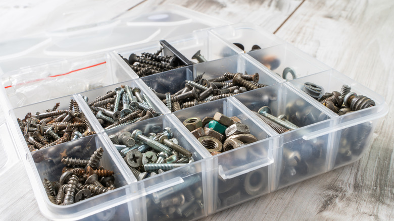 A clear plastic hardware organizer with a lid