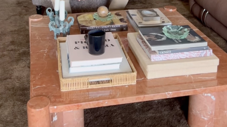 Marble coffee table piled with books and trinkets