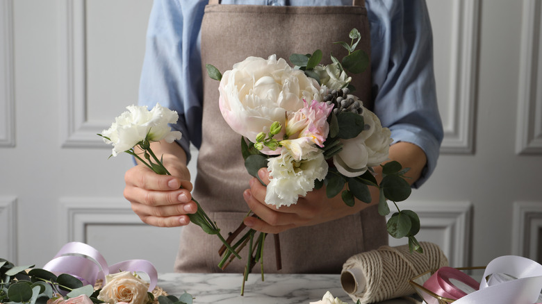 Person arranging white flowers