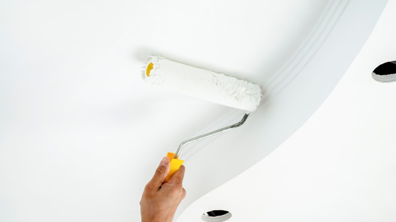 Person painting ceilings with white paint