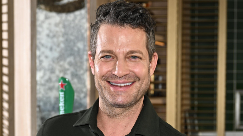 Nate Berkus standing next to a bar