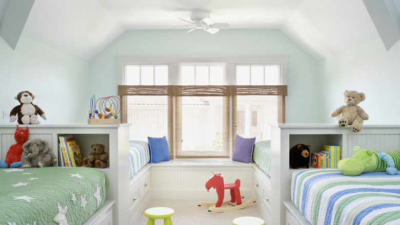 A huge children's bedroom with four beds, along with different bedding and accessories
