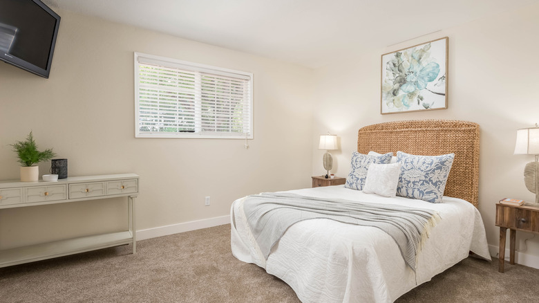 TV mounted in the corner of a bedroom